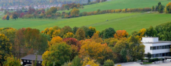 Blick von oben auf eine Landschaft mit den Gebäuden der Biogasanlage der Universität.