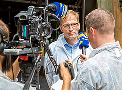 Foto von Vorbereitungen für einen Fernsehbeitrag mit Kamera, Mikrofon, einem Journalisten und Prof. Dr. Rodehutscord
