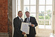 Ministerialrat Wolfgang Arnoldt (r.) überreicht Dr. Klaus Herrmann die goldene Staatsmedaille.