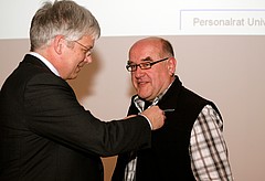 Rektor Dabbert steckt die Ehrennadel der Universität Hohenheim an.