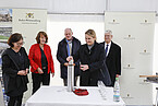 Time capsule for the foundation stone of the future animal science research center HoLMiR: Prof. Dr. Jana Seifert deposits a bezoar stone into the steel cylinder. Bezoars are balls of animal hair and other foreign bodies that accumulate in animals’ stomachs. The capsule also included coins, deposited by State Secretary Gisela Splett (Ministry of Finance BaWü, wearing a red jacket), building plans and a current daily newspaper, deposited by Ministerial Director Dr. Hans J. Reiter (Ministry of Science BaWü, to the right of Splett), and the Hohenheim guidelines for animal experiments, deposited by University President Prof. Dr. Stephan Dabbert (to the right of Reiter). Pictured on the left: Carmen Zinnecker-Busch, from the Stuttgart and Hohenheim University Building Office. Image: University of Hohenheim/Beqiri