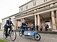 Bei der Übergabe drehten auch Unirektor Prof. Dr. Stephan Dabbert und Verkehrsminister Winfried Hermann eine Runde vor dem Schloss. Neben dem 500. Pedelec: Das ebenfalls neu angeschaffte E-Lastenrad der Universität. | Bildquelle: Universität Hohenheim / Sacha Dauphin