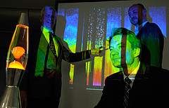 COPS-Leitung Prof. Dr. Wulfmeyer (vorne), Prof. Dr. Kottmeier (links), Dr. Behrendt (hinten rechts) mit Lava-Lampa als einfachem Modell für Gewitterbildung. Im Hintergrund: Grafische Darstellung der Feuchtigkeitsverteilung in der Atmosphäre, vermessen mit Lidar-Laser-Messgerät. Bild: Uni Hohenheim/Fleck